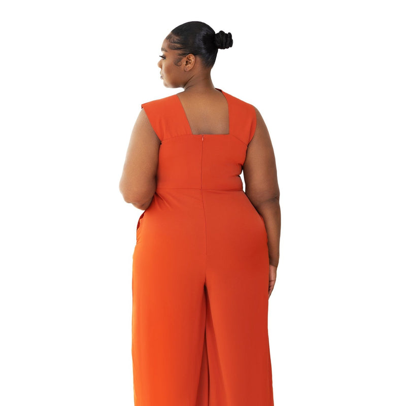 Model wearing Onika Orange Jumpsuit with asymmetrical neckline back view