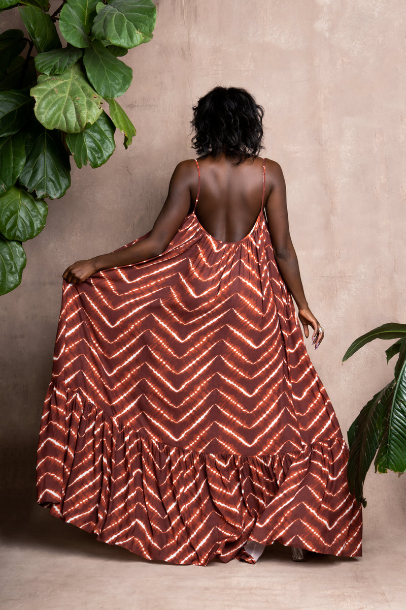 Model wearing orange tie-die African print summer dress back view