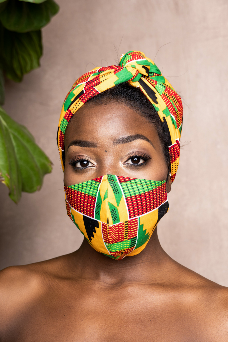 woman wearing african print headwrap and mask yellow, green, red